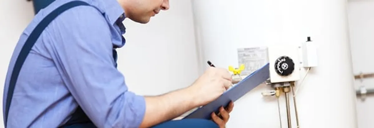Water heater repair technician inspecting the unit and recording service notes in Akron, OH